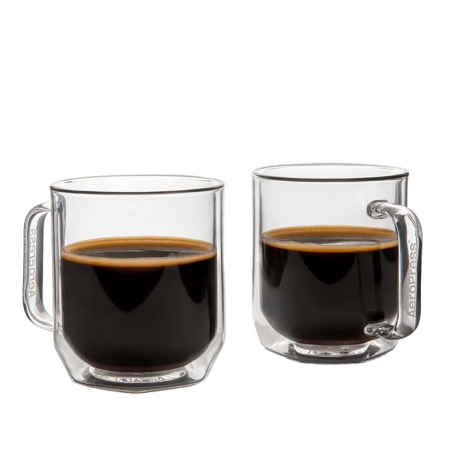 Two clear glass mugs filled with black coffee on a white background