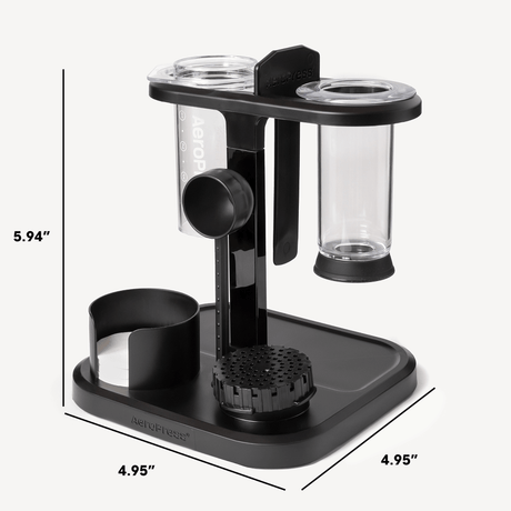 Black and clear coffee brewing device with measurements on a white background