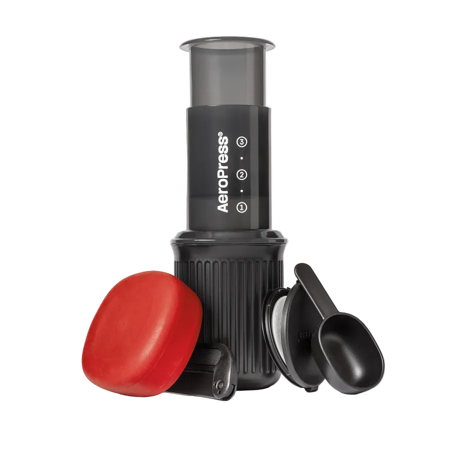 AeroPress Go coffee maker with red lid and black scoop on a white background