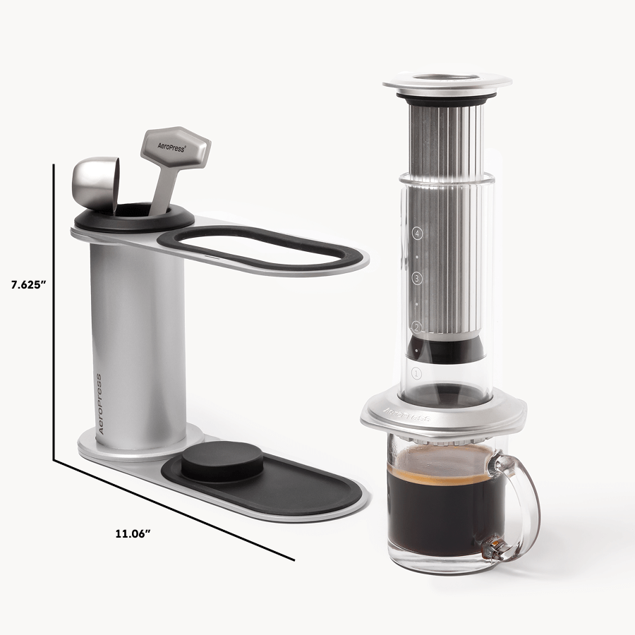 Aeropress coffee maker with a glass mug of coffee on a white background