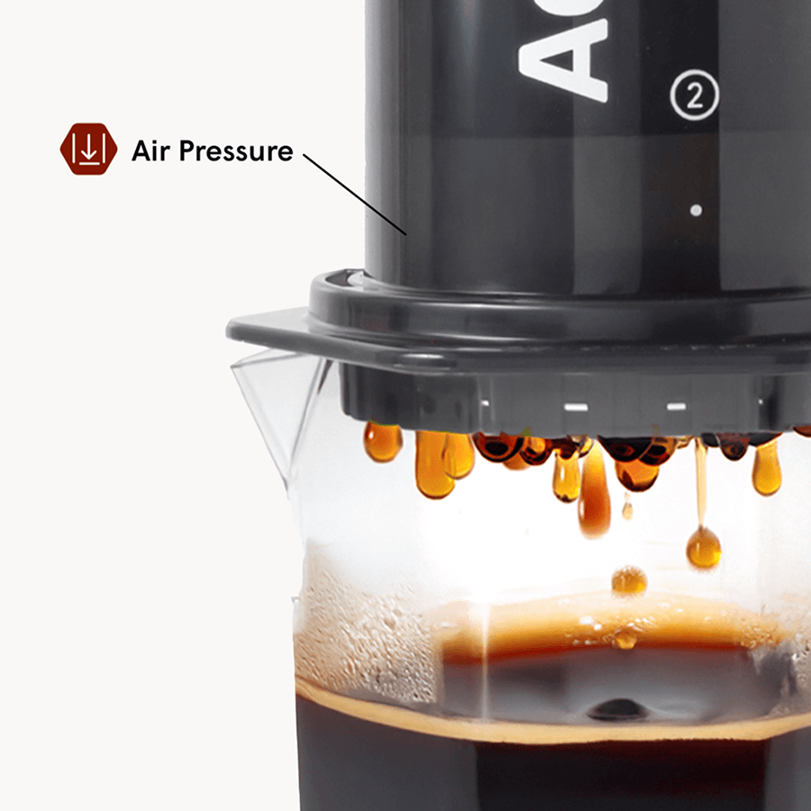 Coffee maker with air pressure feature in action, showing coffee dripping.