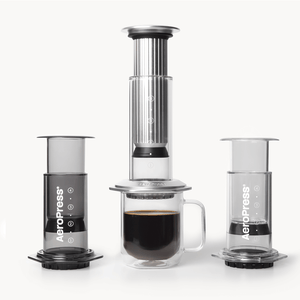 AeroPress coffee maker lineup with a cup of coffee on a white background