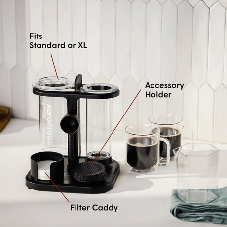 Black coffee accessory holder with labeled parts on a kitchen counter.