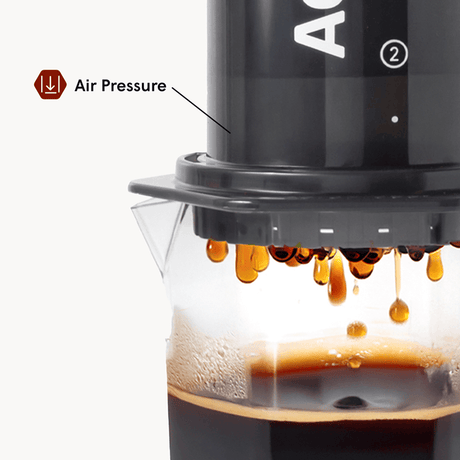 Coffee maker with air pressure feature in action, showing coffee dripping.