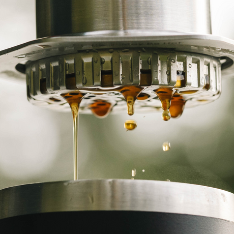 Close-up of a coffee machine with coffee dripping from the spout. #color_silver